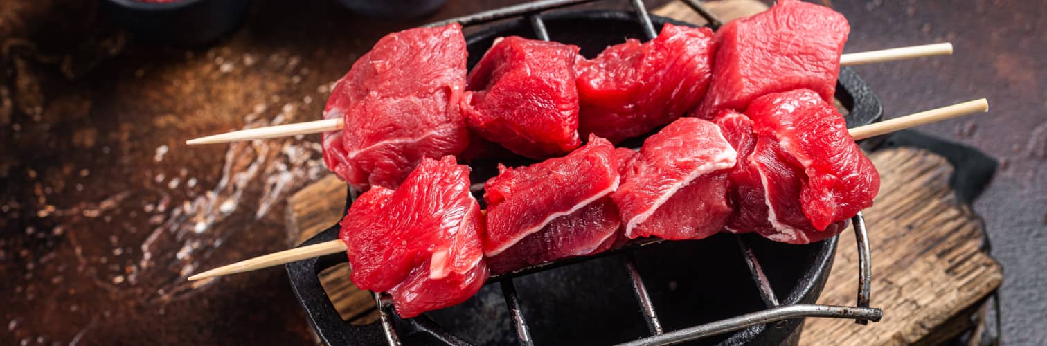 Selección de chuletones y filetes de ternera con grasa infiltrada sobre fondo oscuro.